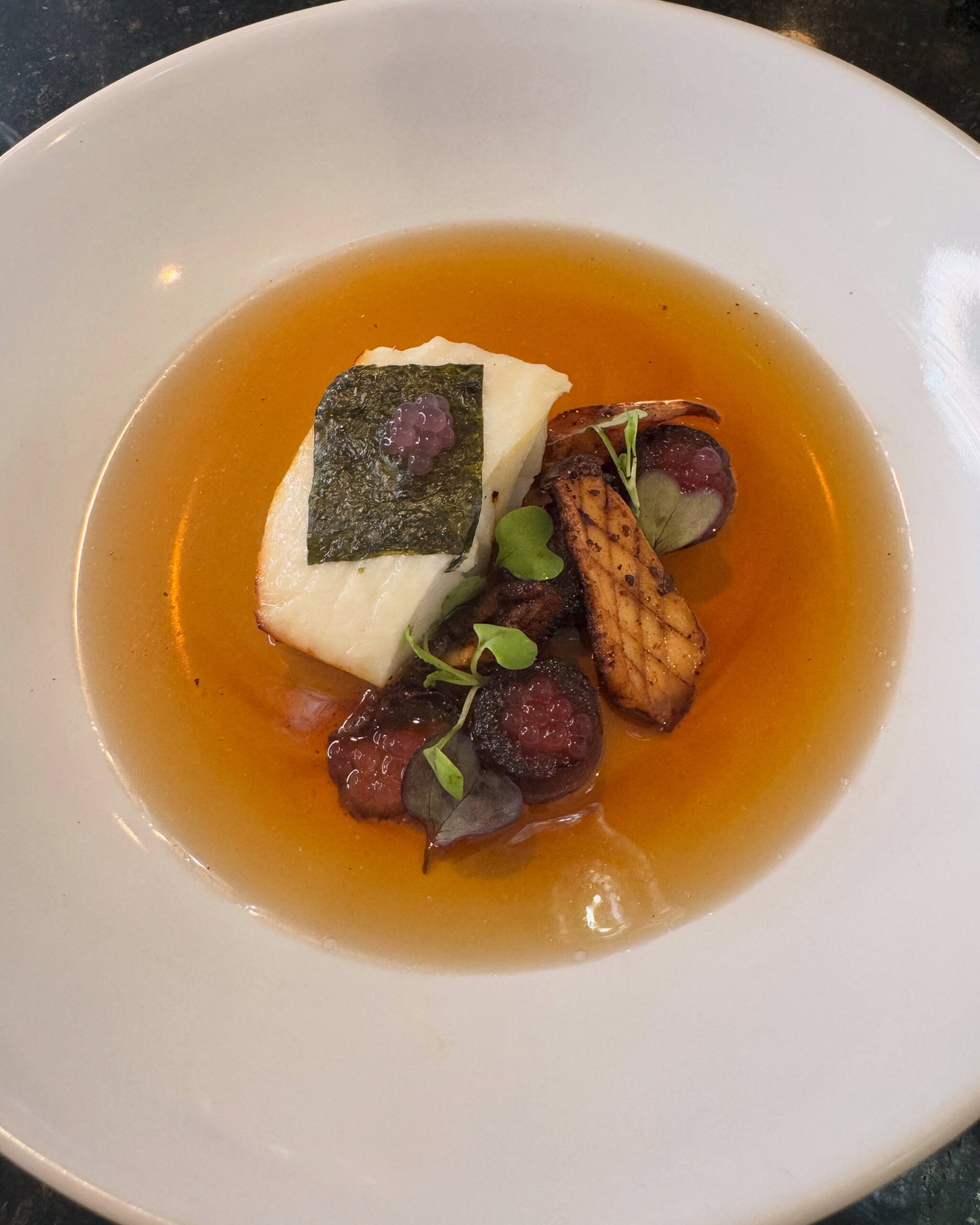 Chilean Sea Bass with Braised Daikon, Watermelon Radish Pearls, Mixed Mushrooms, and Crispy Nori 