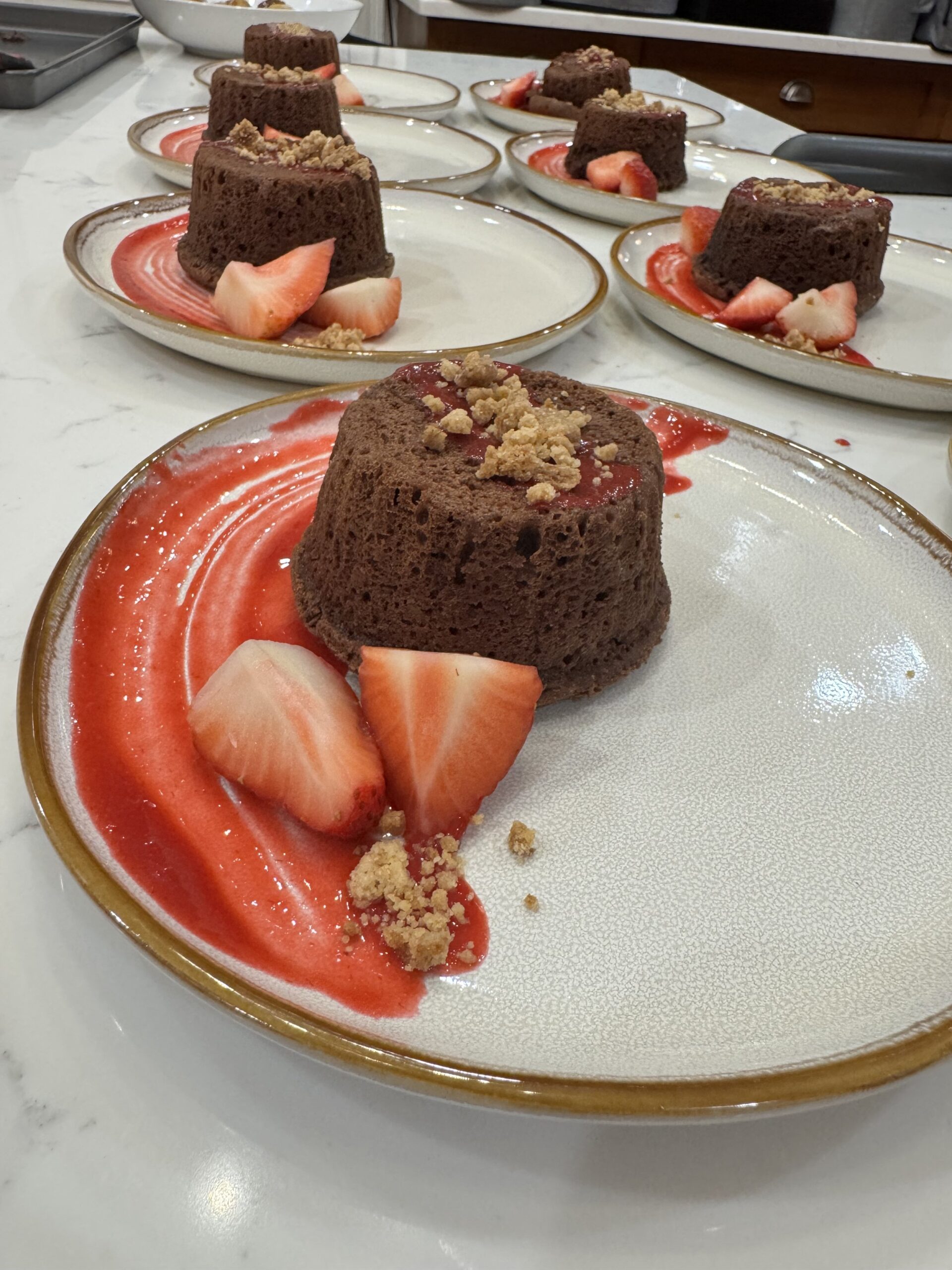 Chocolate lava cakes - strawberry slices, strawberry sauce, and crumbled topping