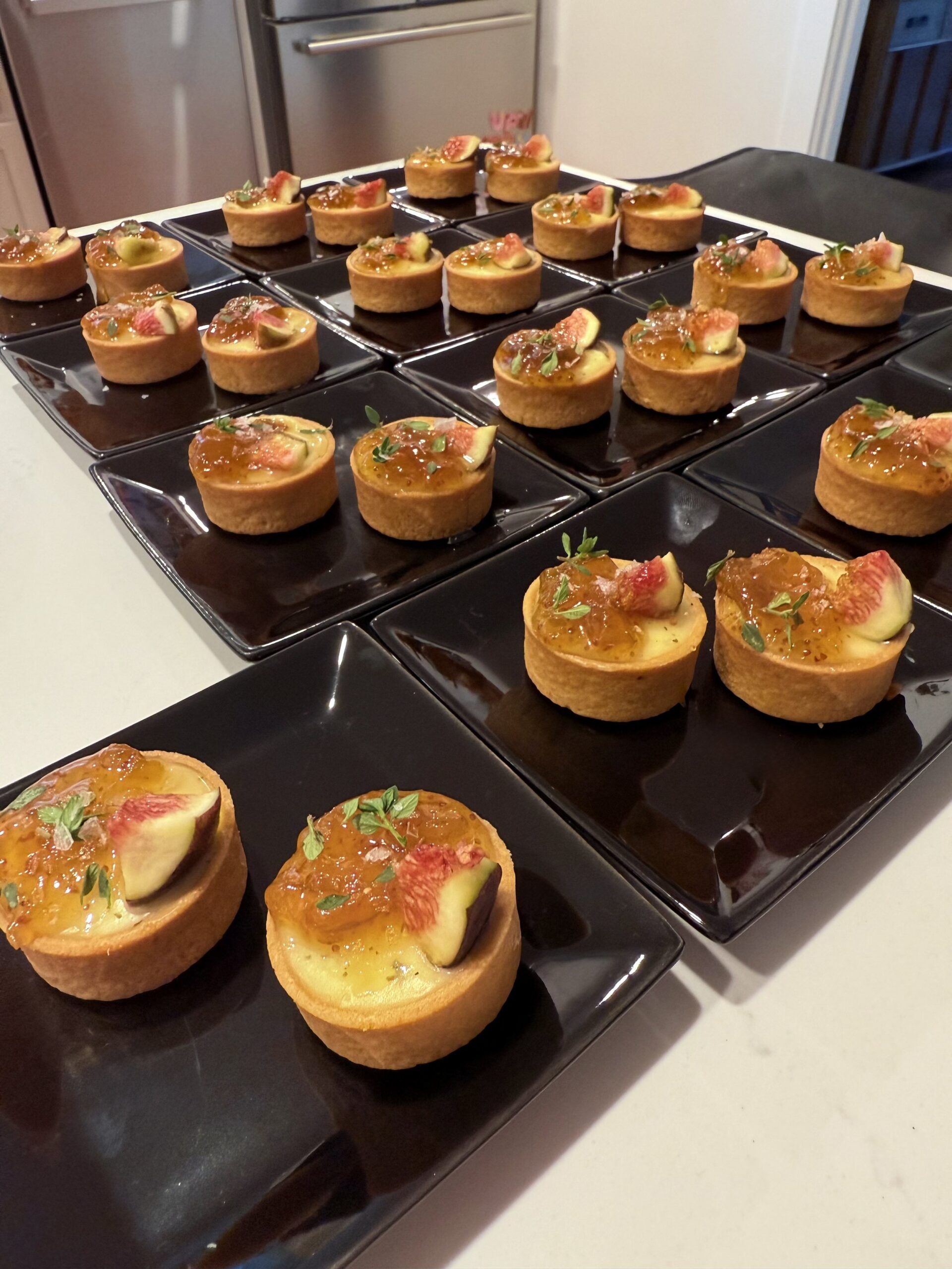 fig tartlets with fig slices, herbs, and caramelized topping